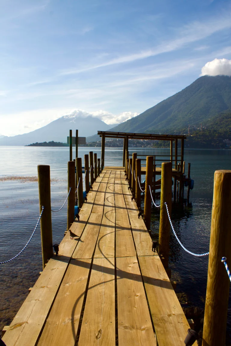 Wooden dock reaching into Lake Atitlán with the volcanoes on the far shore, Guatemala