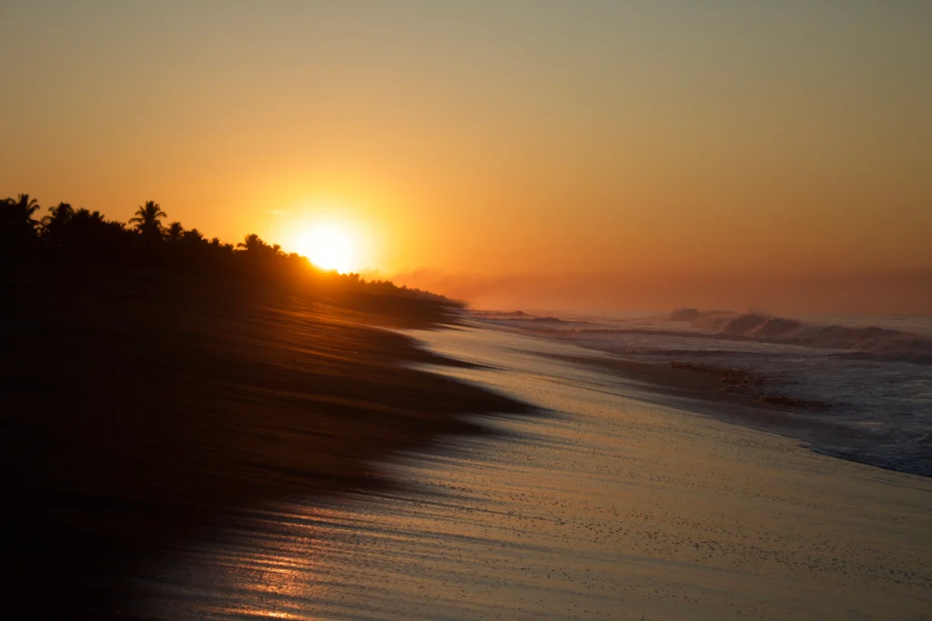 Amanecer sobre el oleaje del Pacífico y la arena negra de Monterrico, Guatemala