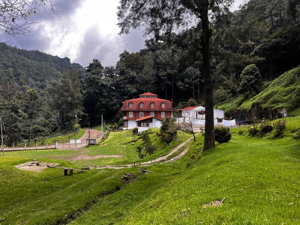 La maison au toit rouge de la Finca San Rafael de las Hortensias, entre les prés et les collines boisées